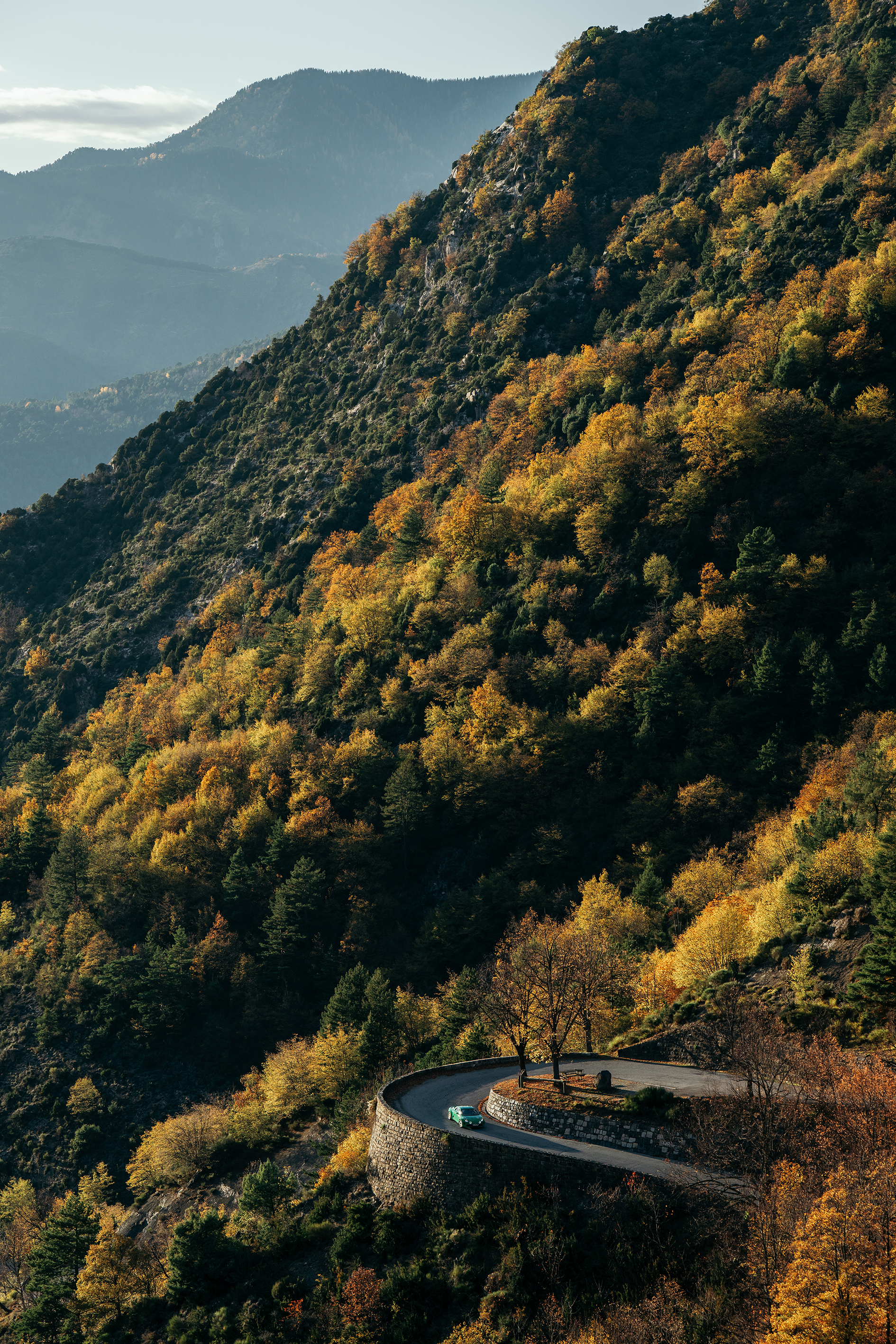 Ravage Groupe 4 vert sur une épingle du col de Turini, minuscule au pied d'un versant boisé aux couleurs d'automne.